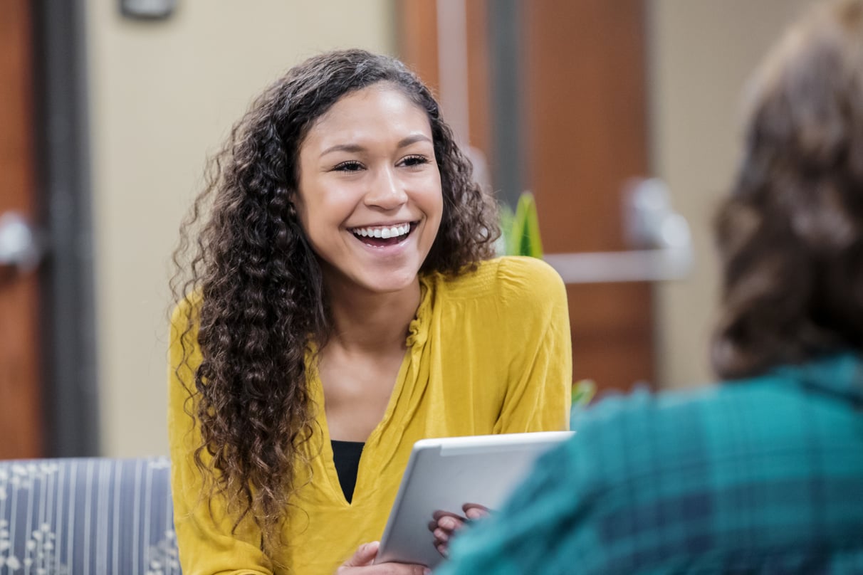 Young social worker sits with colleague